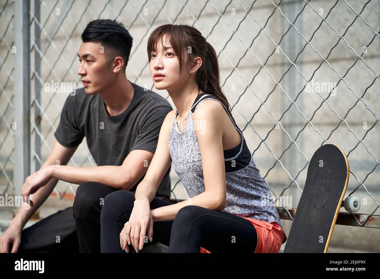 young asian adult couple man and woman resting relaxing outdoors after exercise Stock Photo