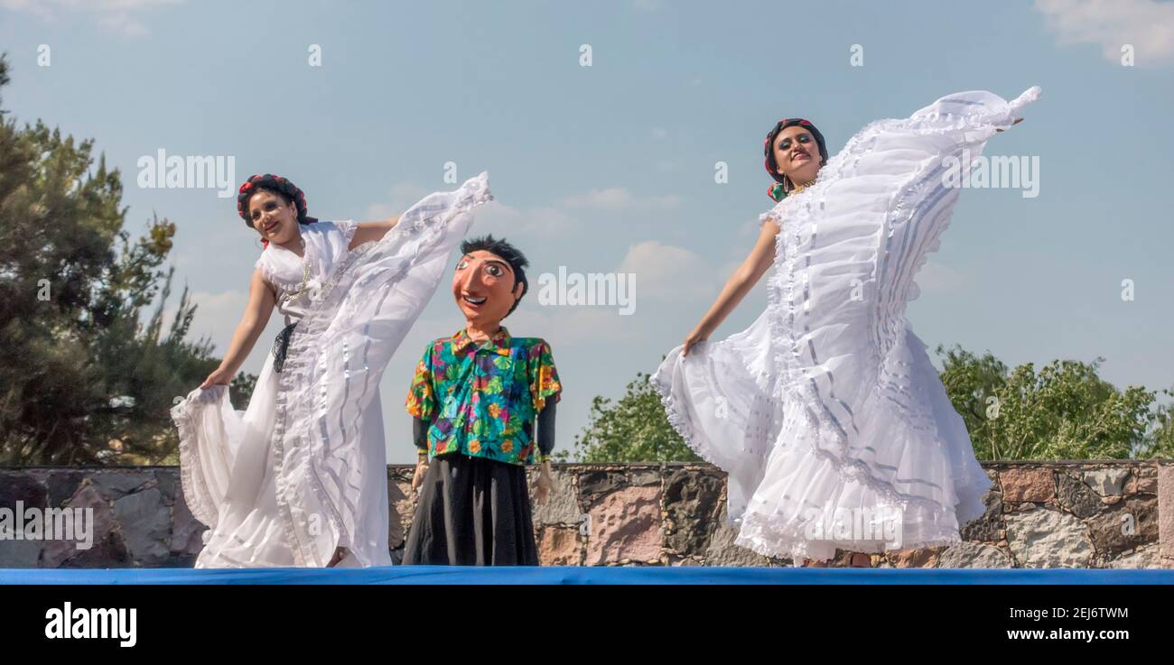 Girls in traditional Mexican costumes dance in in front of a mannequin in San Miguel de Allende, Guanajuato, Mexico Stock Photo