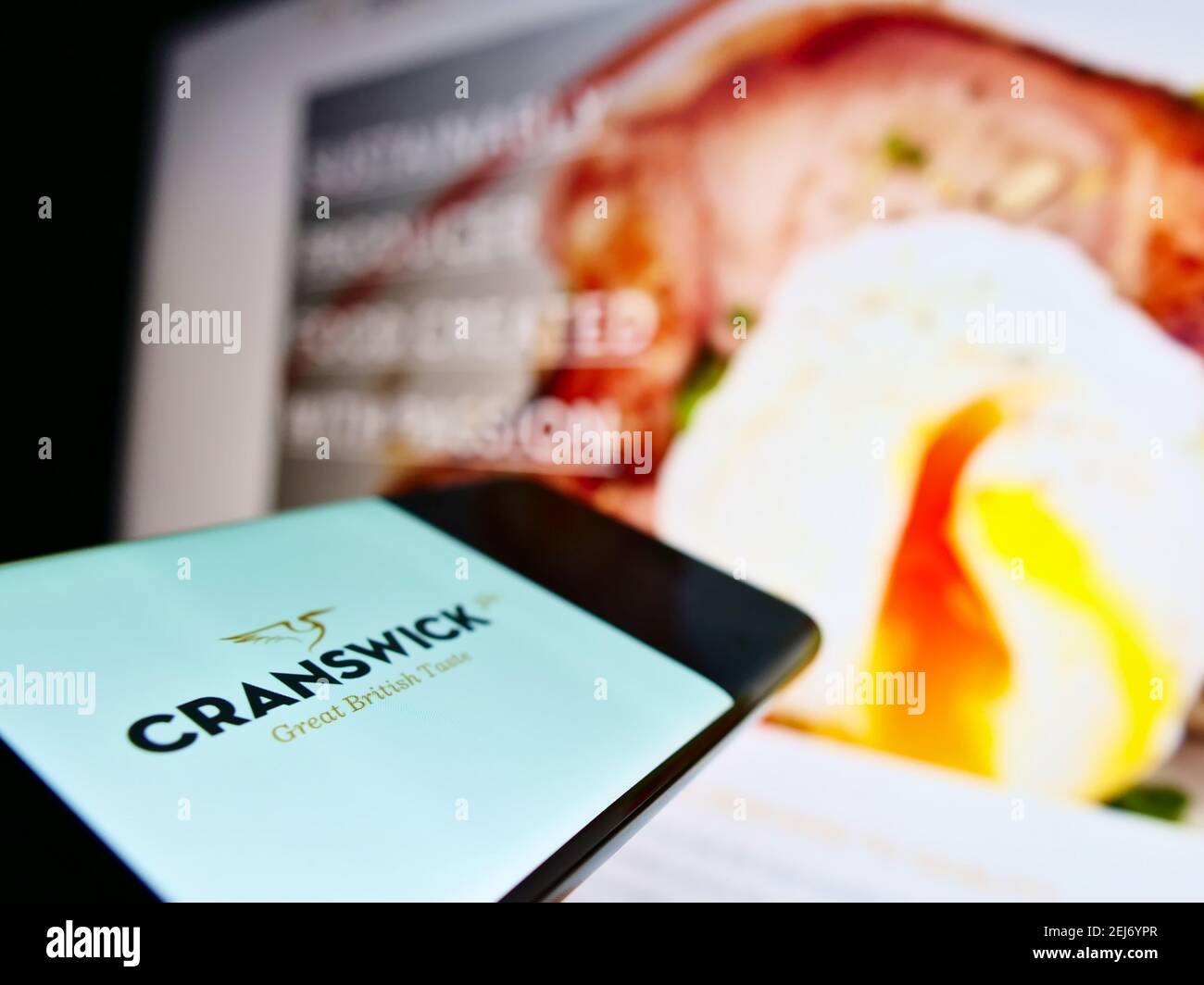 Person holding smartphone with logo of British food producing company