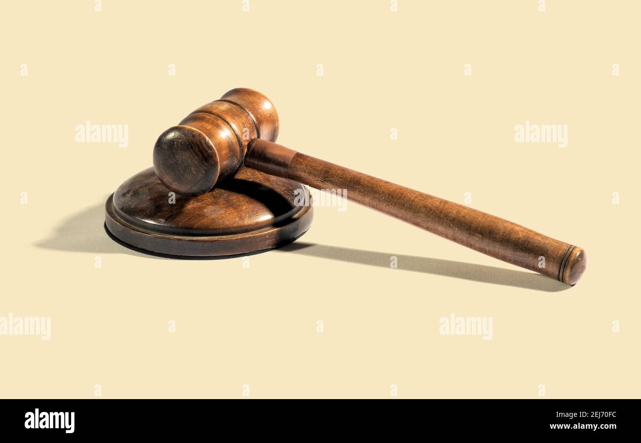Traditional wooden judge gavel placed on round block on beige background during court Stock Photo