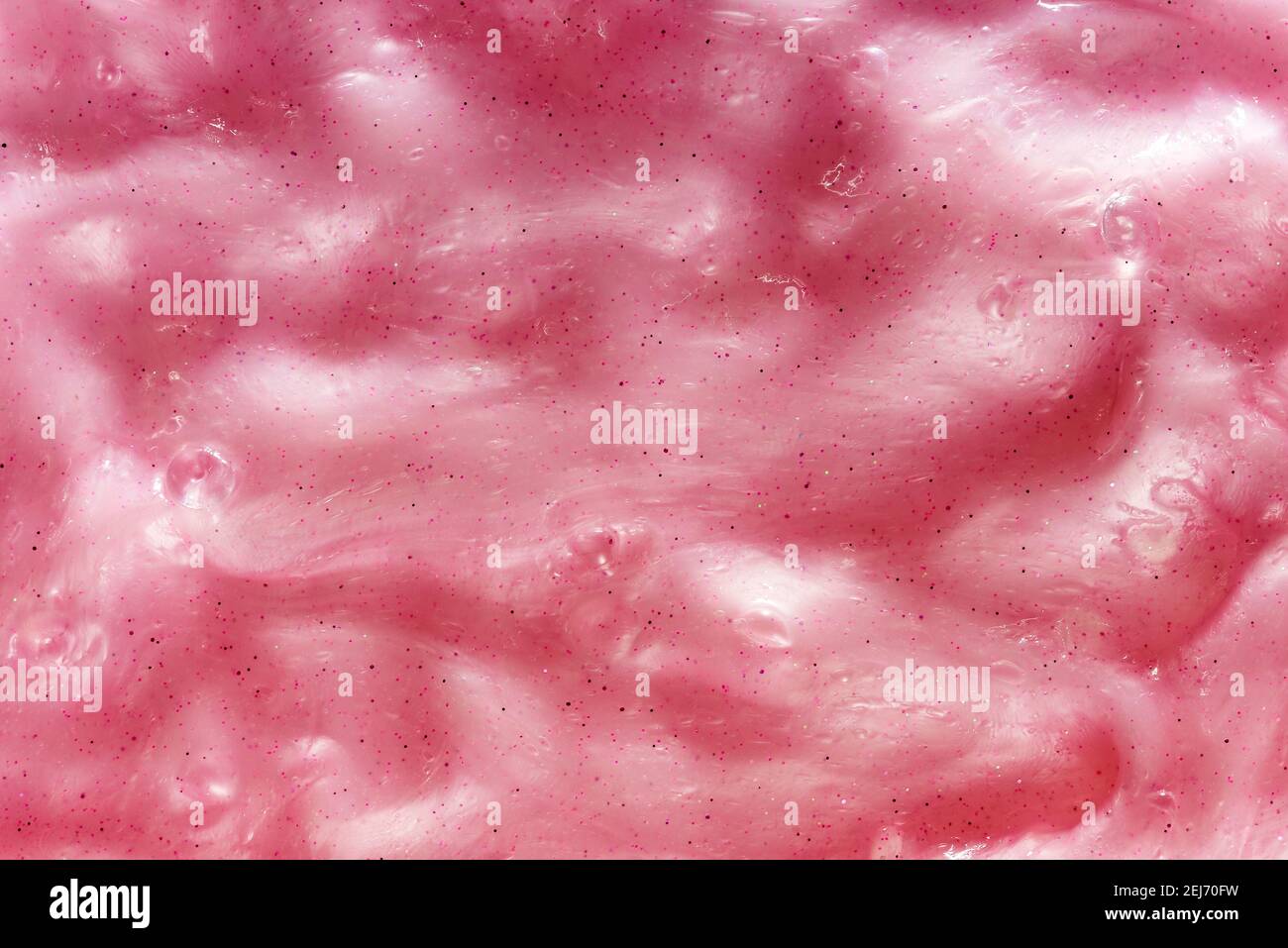 Full frame background of gooey pink slime, a kids toy produced with guar gum with an amorphous malleable squishy slimy texture in close up detail Stock Photo
