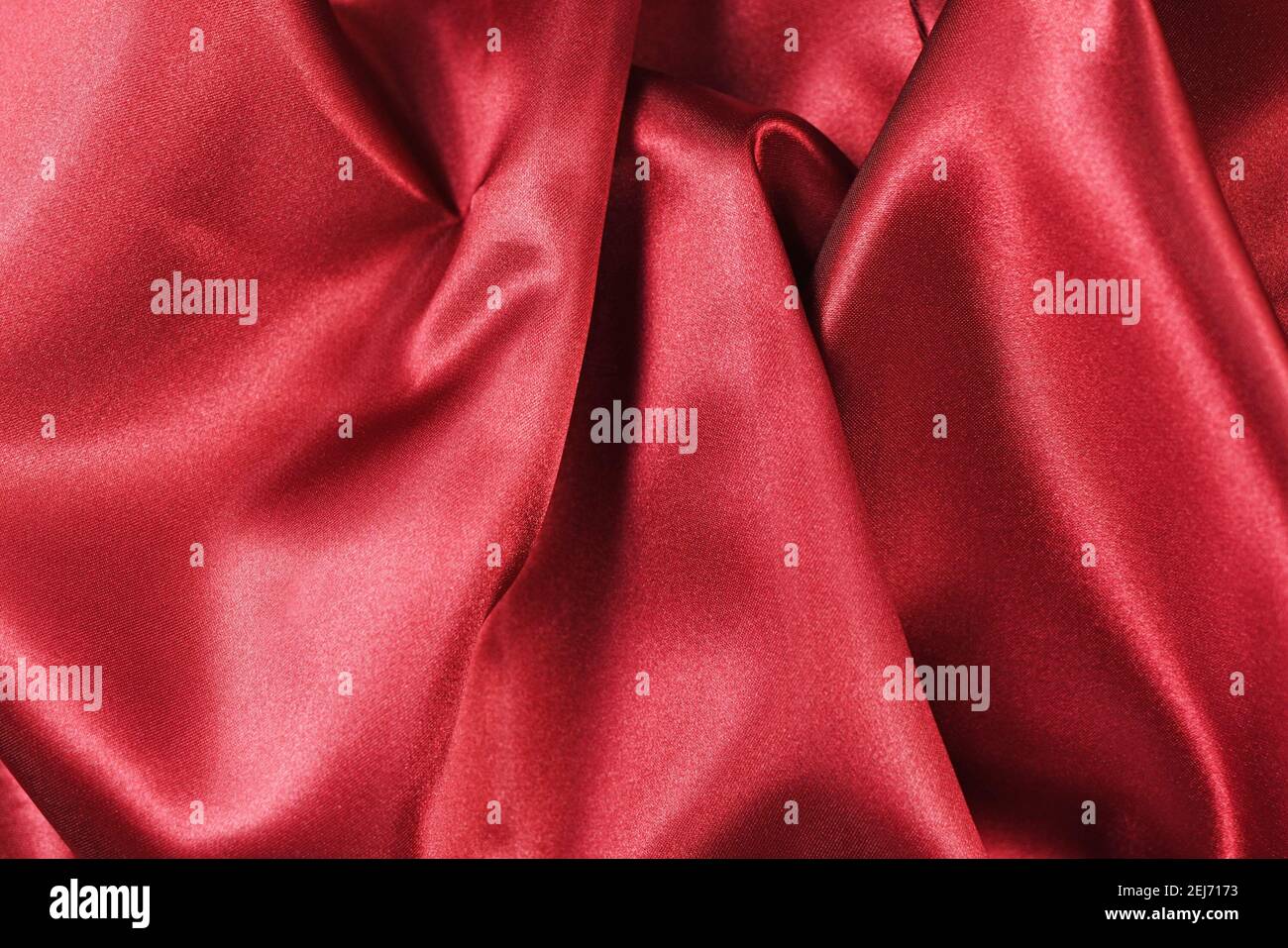 Shiny red satin textile texture with folds Stock Photo