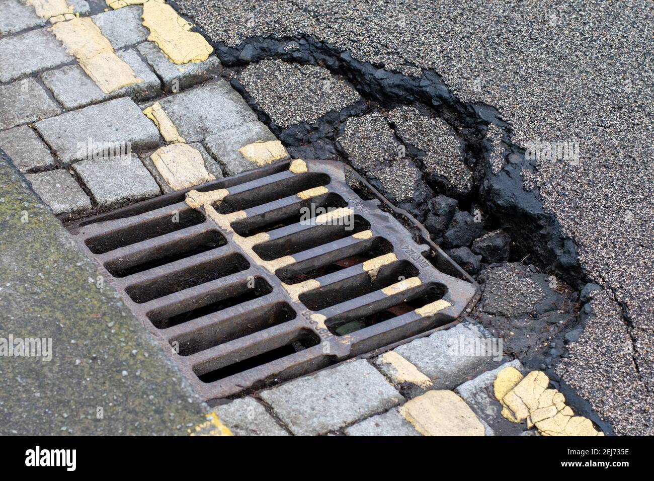 Collapsing cracked street road rain drain cover Stock Photo Alamy