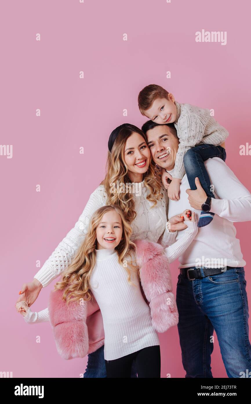 Family portrait. Parents and their children. Over dark pink Stock Photo ...