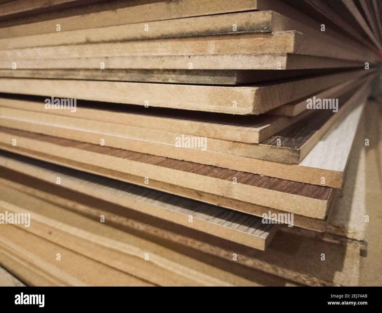 Chipboard plywood sheets are stacked on top of each other. A stack of