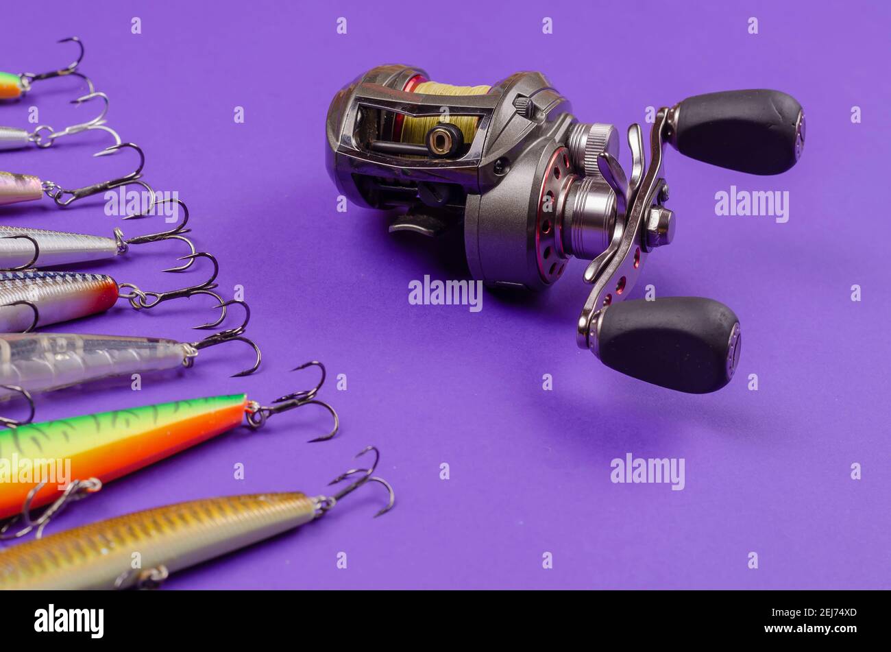 Artificial lures for fishing for predatory fish and a fishing reel on a  blue background. Random wobblers are lined up. Baitcasting reel. Fishing,  tack Stock Photo - Alamy