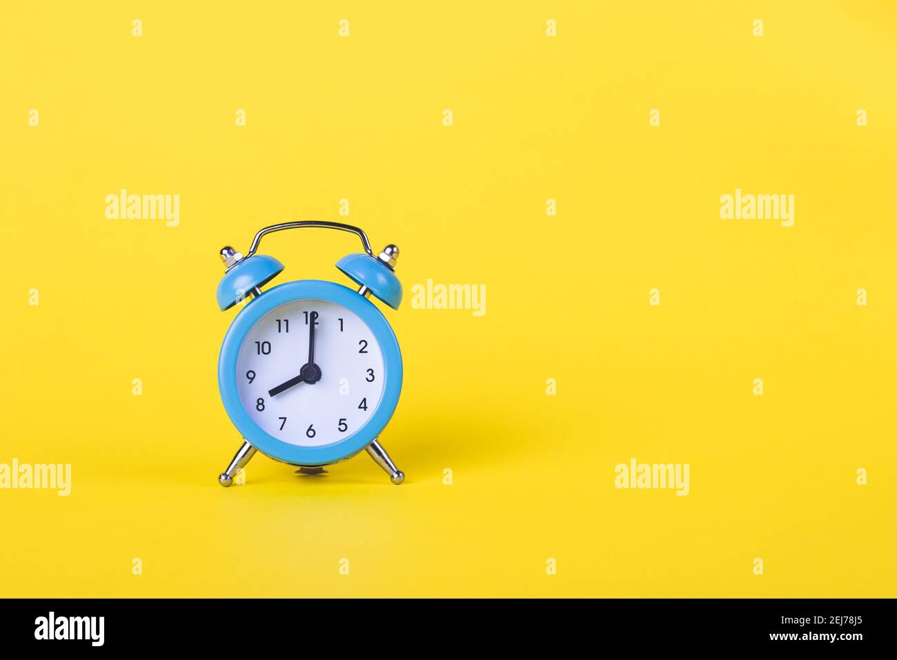 The alarm clock shows 8 am. Morning time. Clock face. Yellow background, deadline concept. Copy space, empty place for text. Business template. Bright Stock Photo