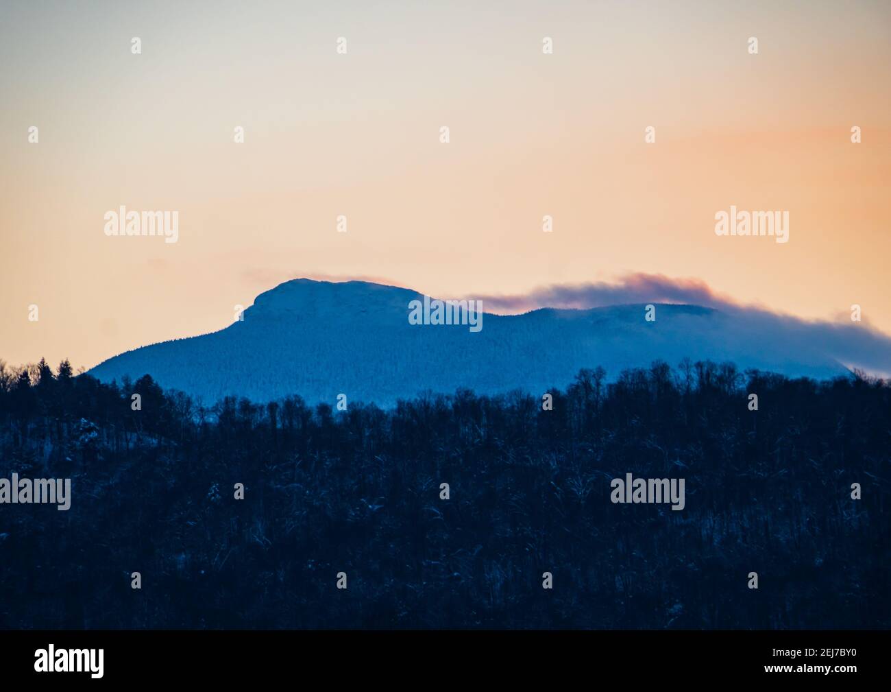Camel's Hump Mountain silhouetted by setting sunlight Stock Photo