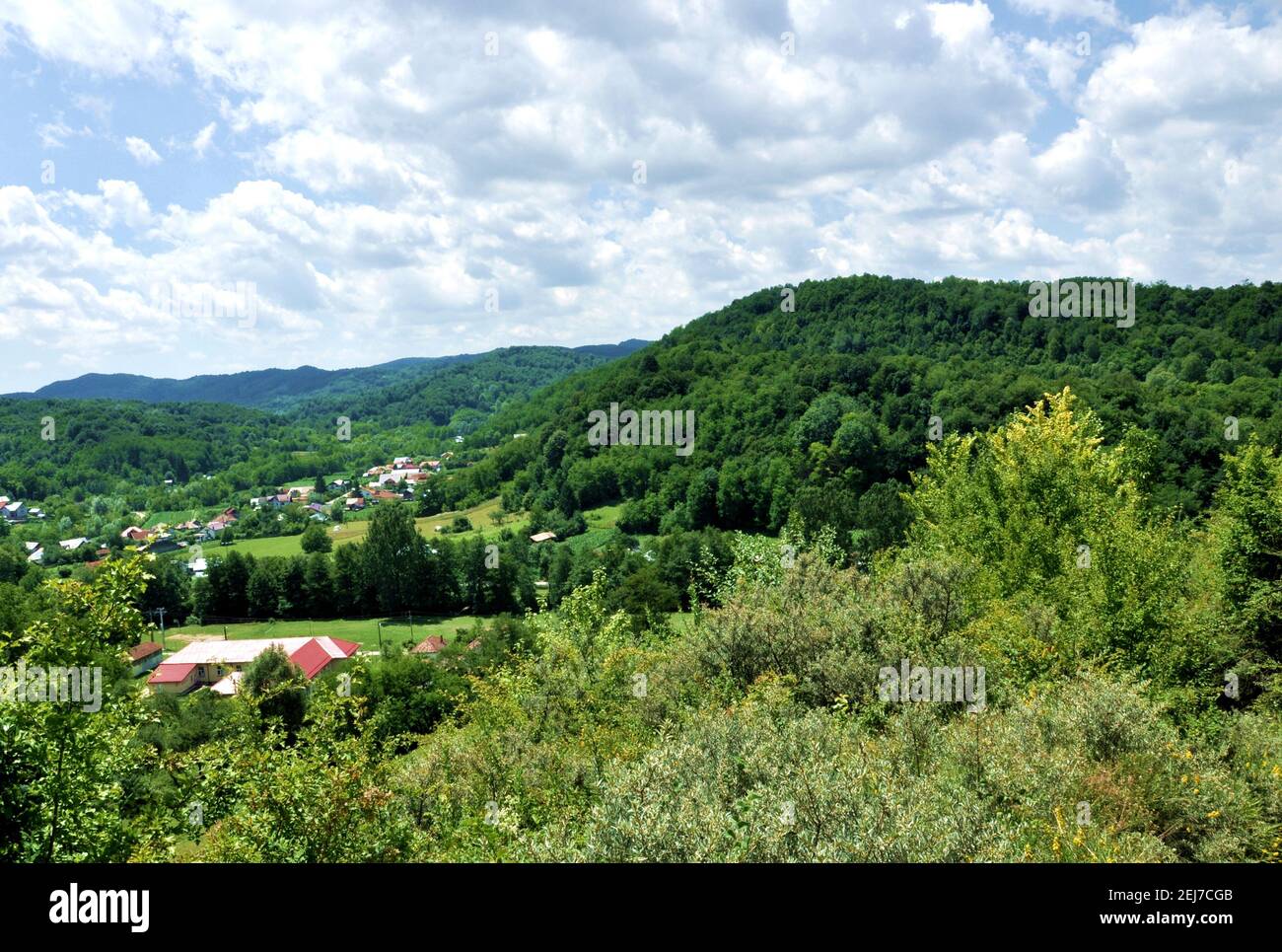 Scenic landscape of rural area in Romania, with hills and houses on a cloudy sky background Stock Photo