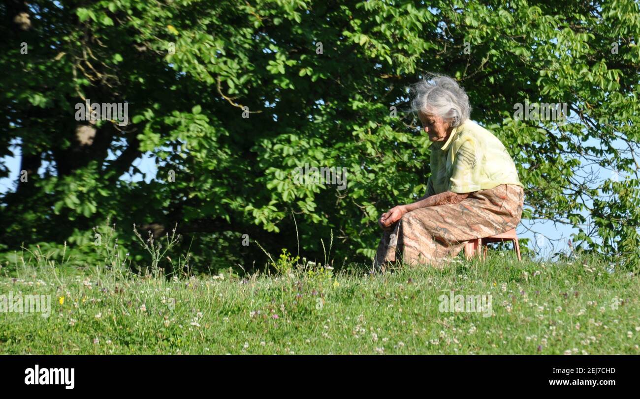Mature woman sitting on chair hi-res stock photography and images - Alamy