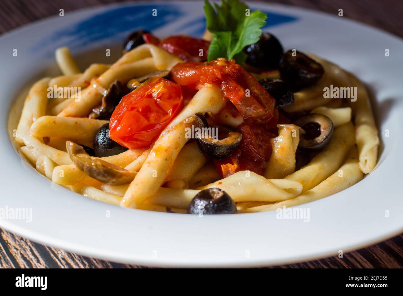 Fusilli al ferro with black olives and cherry tomatoes Stock Photo