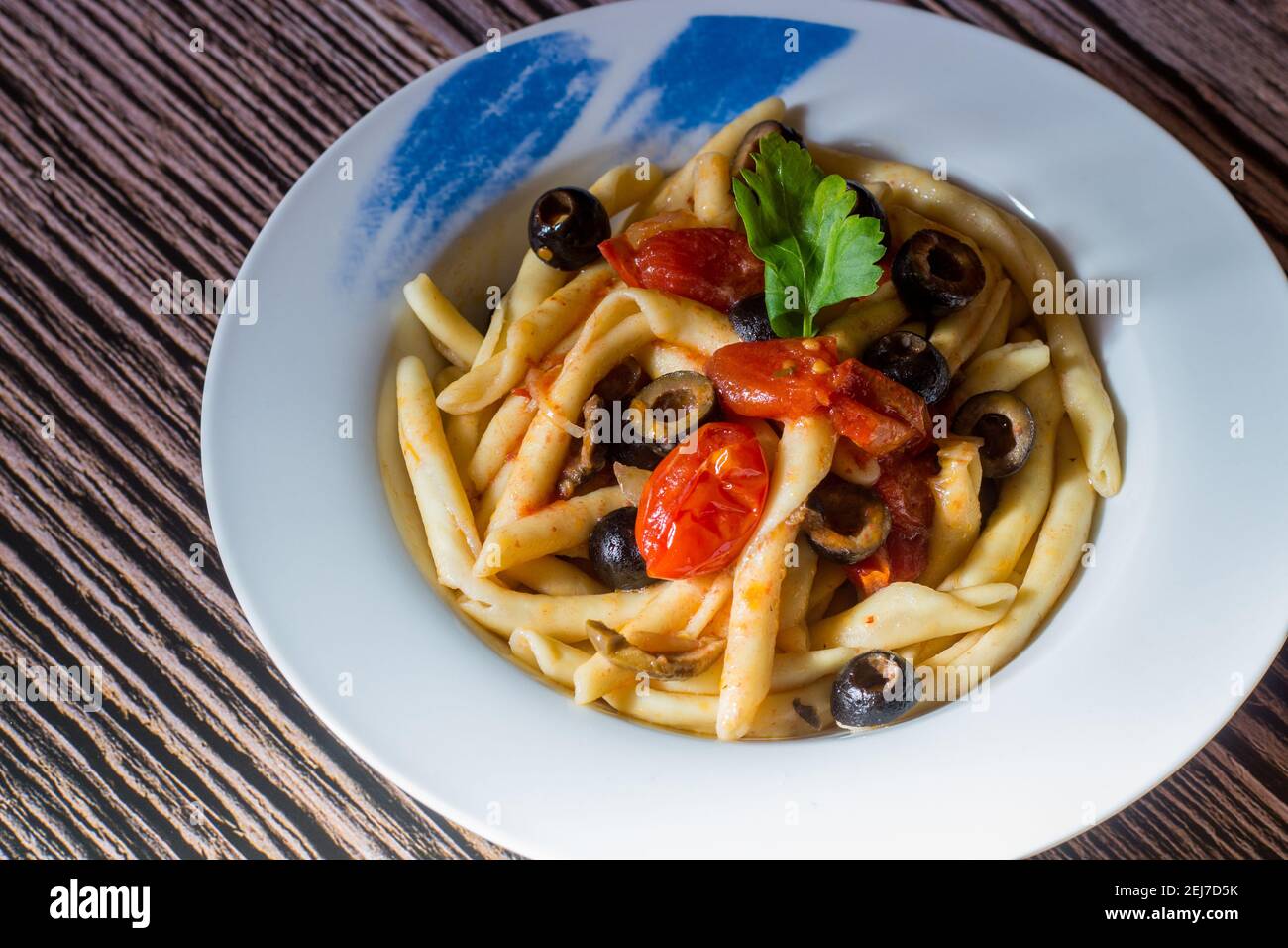 Fusilli al ferro with black olives and cherry tomatoes Stock Photo