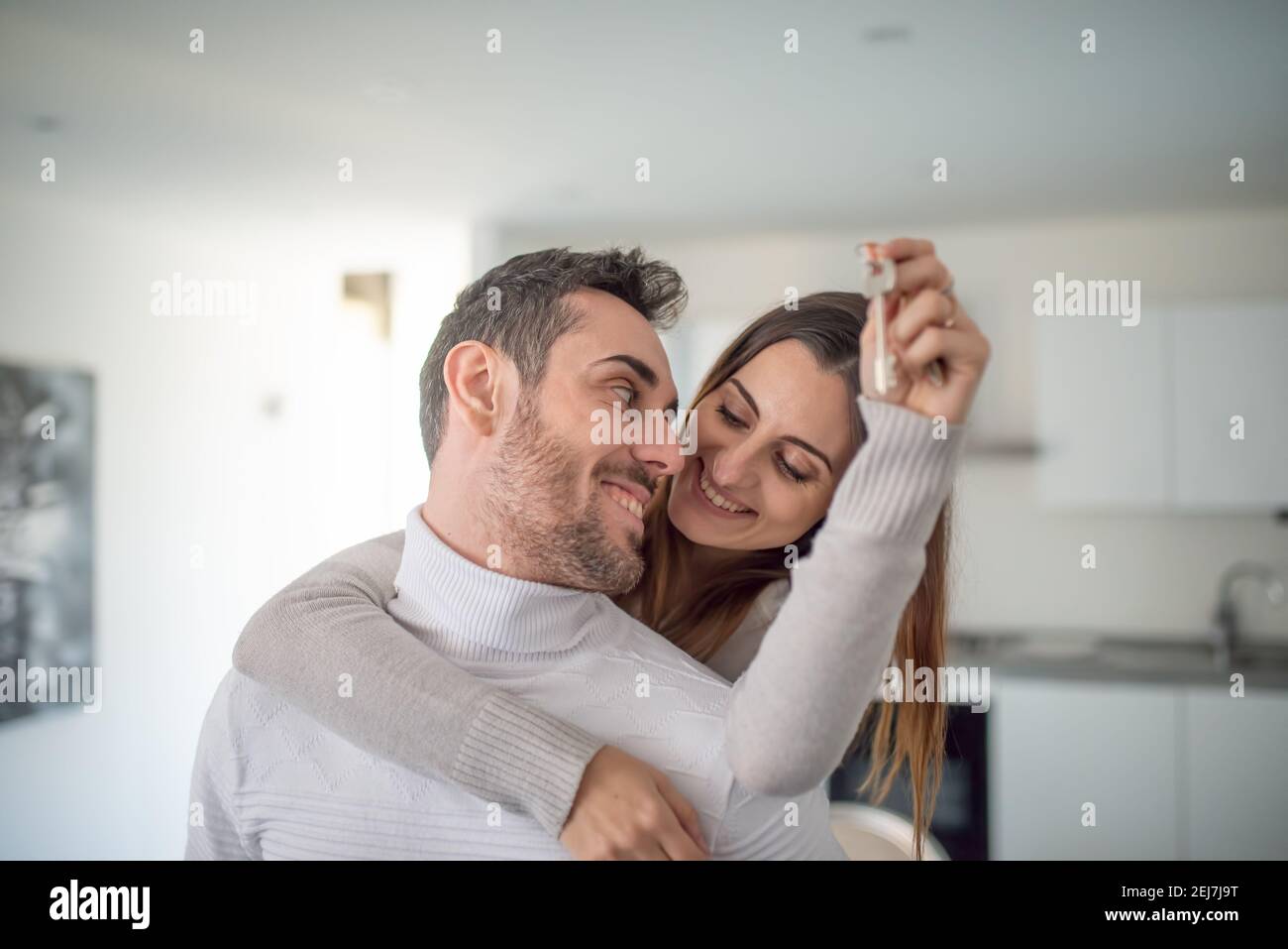 Happy couple showing the keys of their new house Stock Photo - Alamy