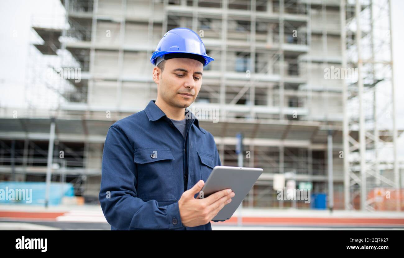 Young engineer man wearing an helmet working on tablet pc Stock Photo