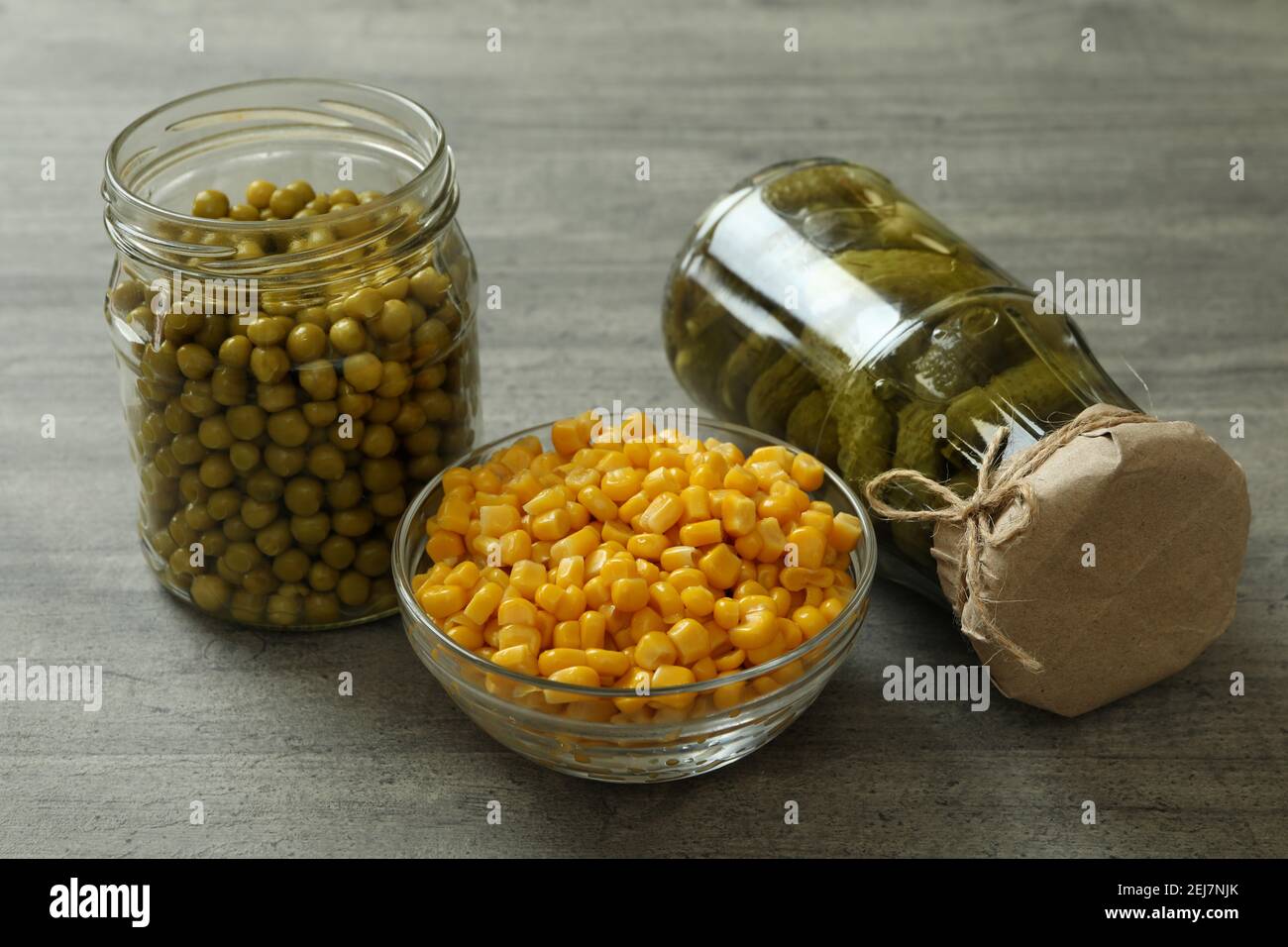 Pickled cucumbers, corn and peas on gray background Stock Photo