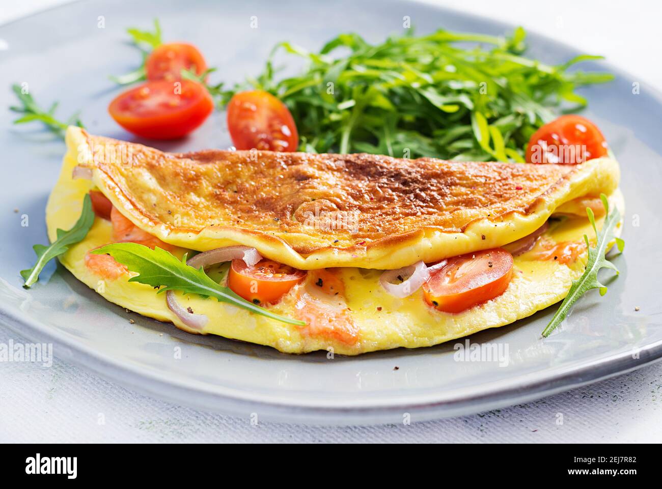 Keto breakfast. Omelette with cheese, tomatoes and avocado on light