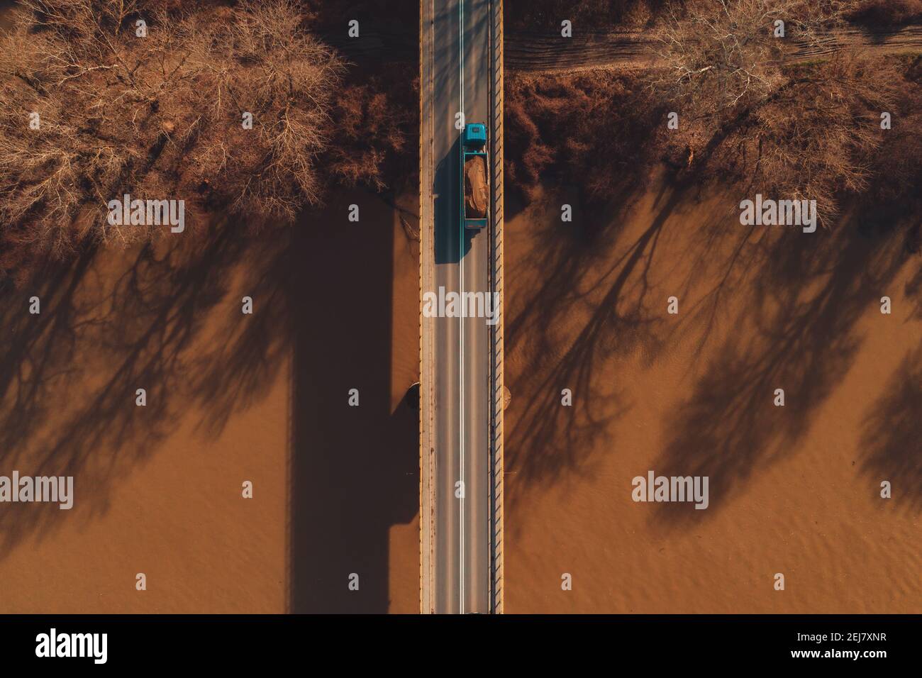 Aerial view of truck transporting dirt over the concrete bridge, top view Stock Photo