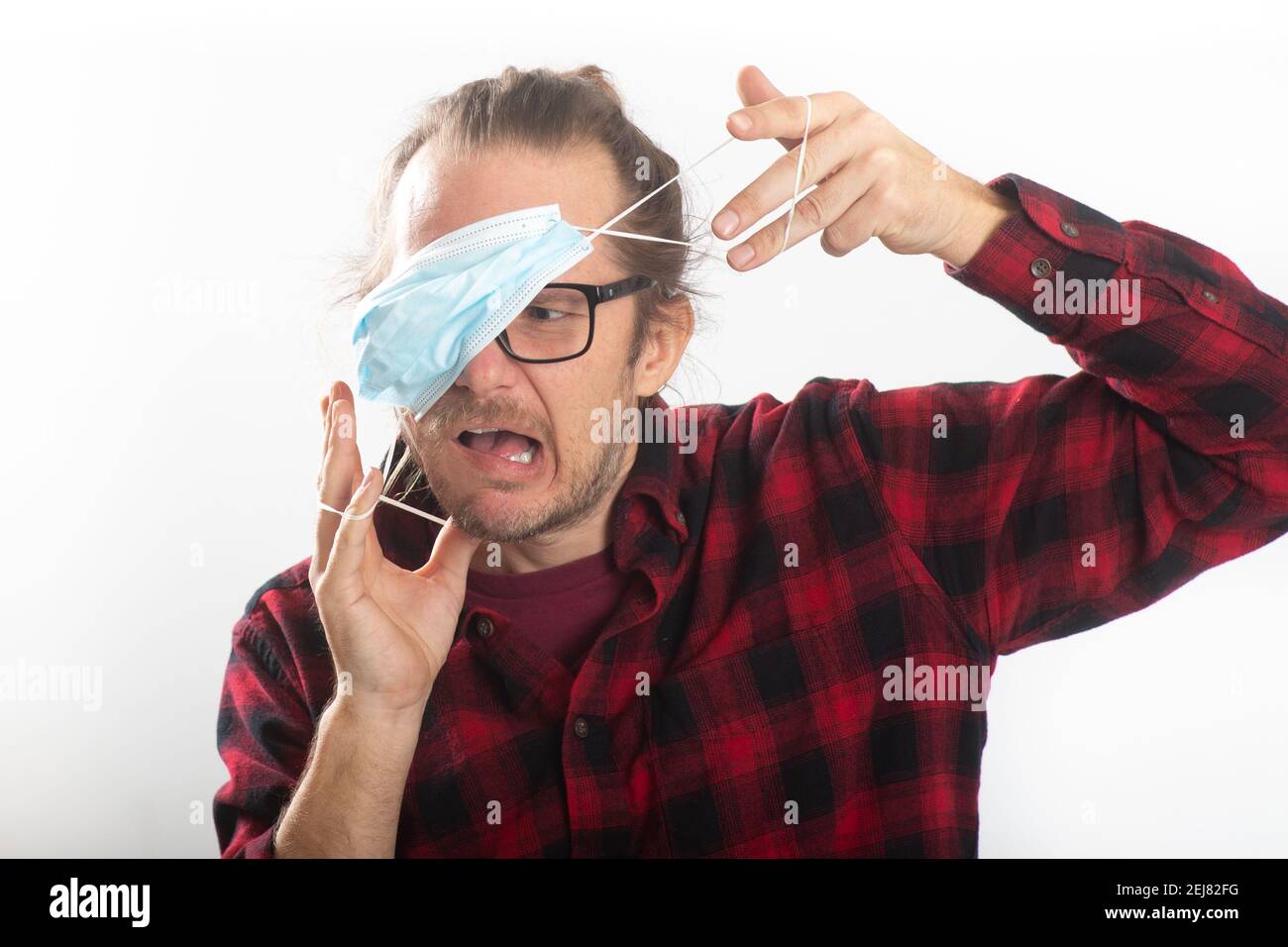 Portrait of man having trouble wearing a protective mask Stock Photo