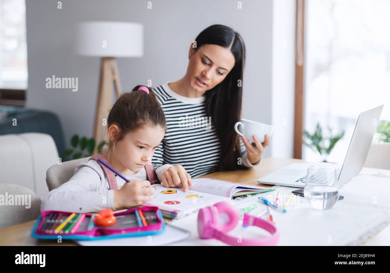 Mother with school girl indoors at home, distance learning and home ...