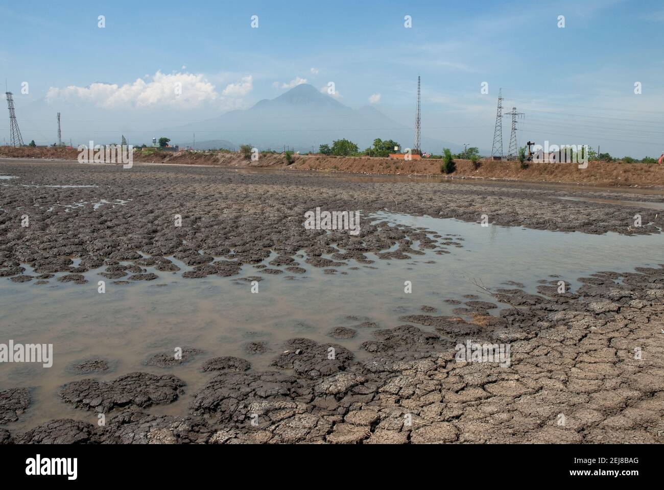Mud lake environmental disaster which developed after drilling incident with volcano in background, Porong Sidoarjo, near Surabaya, East Java, Indones Stock Photo
