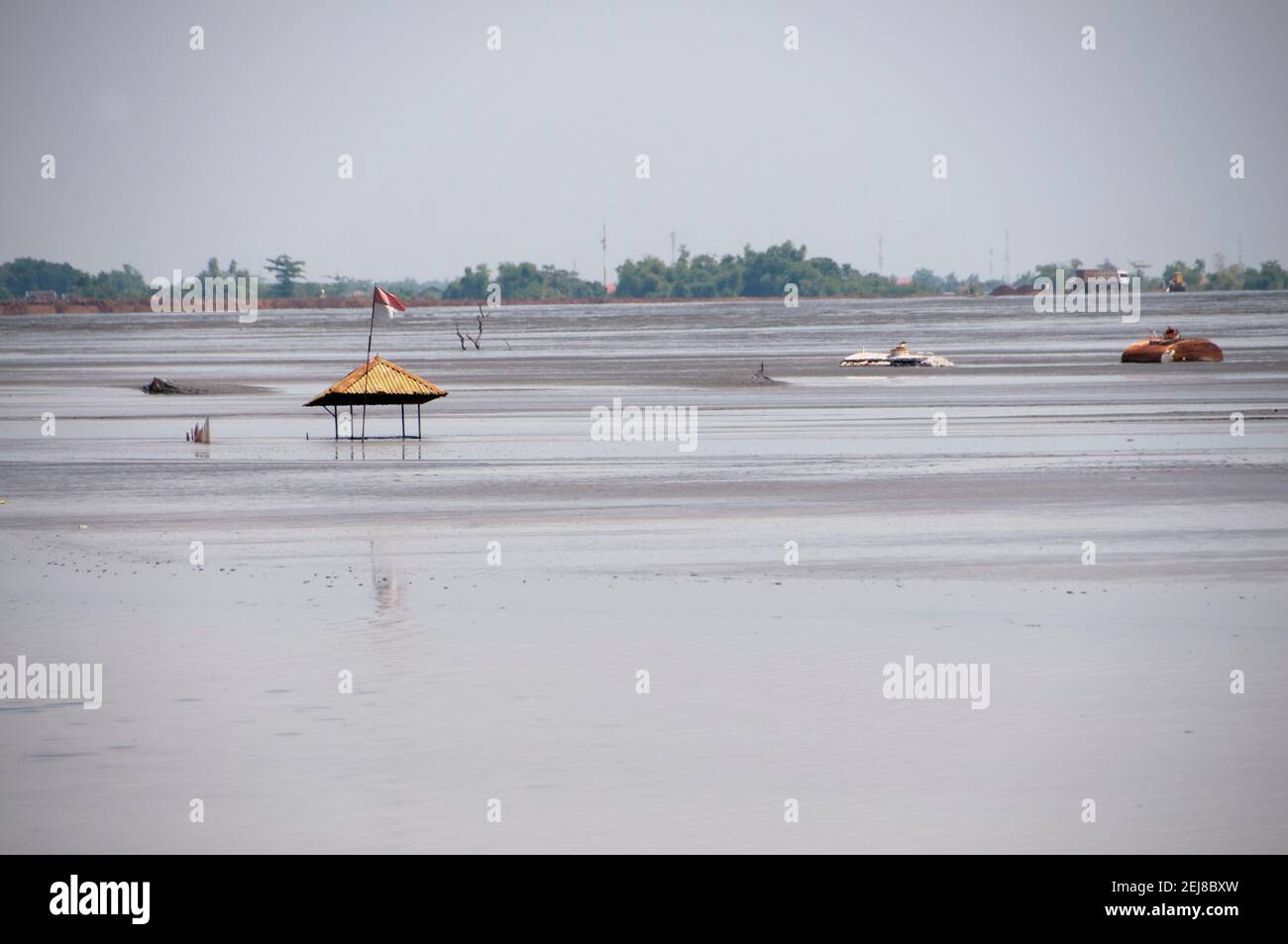 Top of mosque barely visible in mud lake environmental disaster and mud flow geyser which developed after drilling incident, Porong Sidoarjo, near Sur Stock Photo