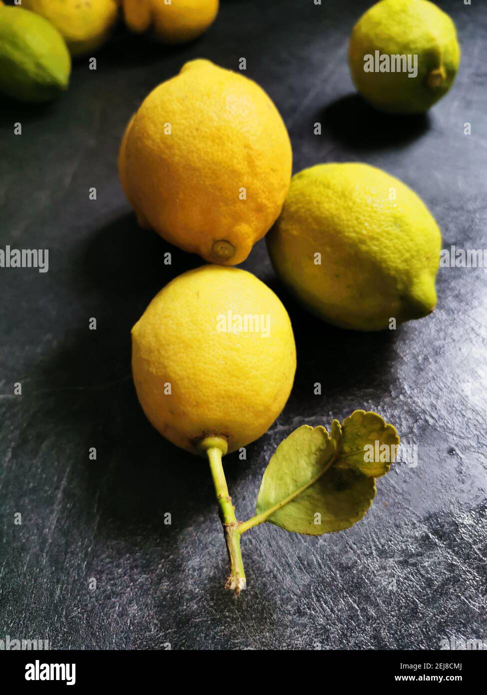 The fresh lemons are on the black stone kitchen table. Top view with copy space, flat lay. Stock Photo