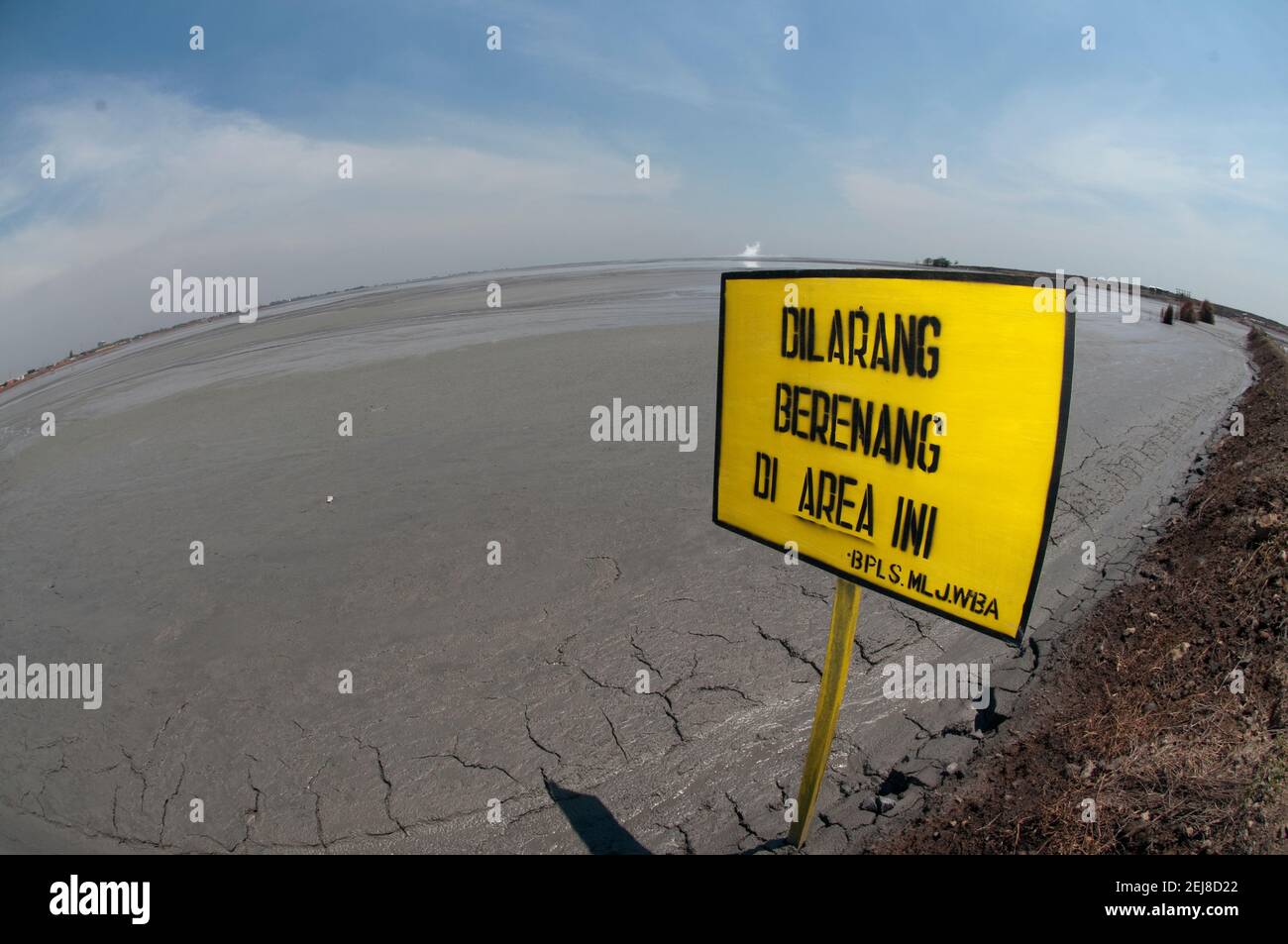 Do not swim sign in Indonesian in mud lake environmental disaster which developed after drilling incident, Porong Sidoarjo, near Surabaya, East Java, Stock Photo