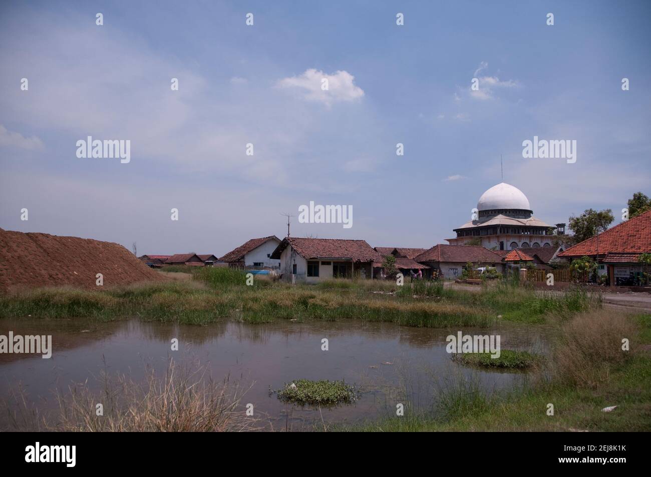 Abandoned village and levee holding back mud lake environmental disaster which developed after drilling incident, Porong Sidoarjo, near Surabaya Stock Photo