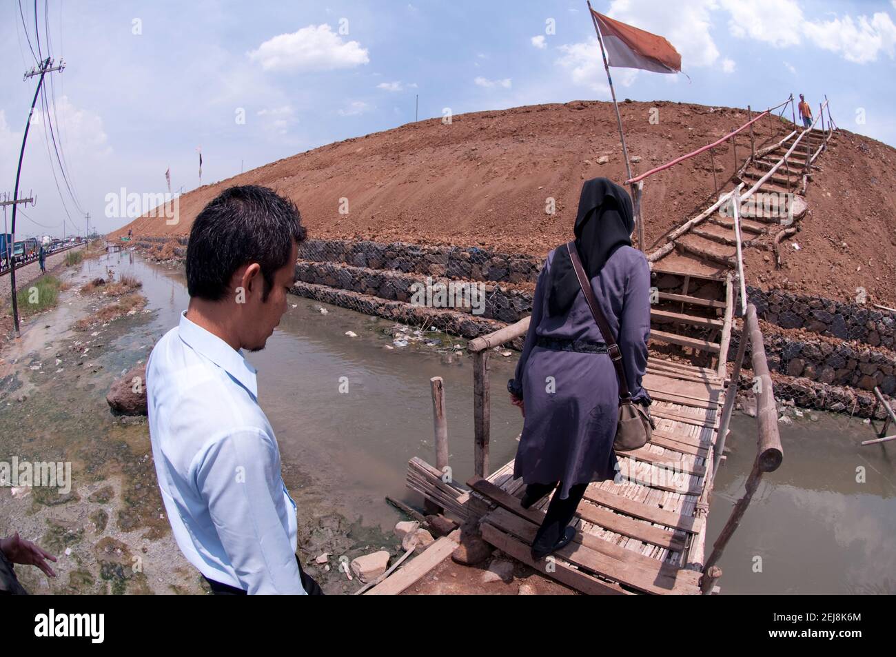Disaster tourists visiting mudflow disaster levee crossing small bridge ...