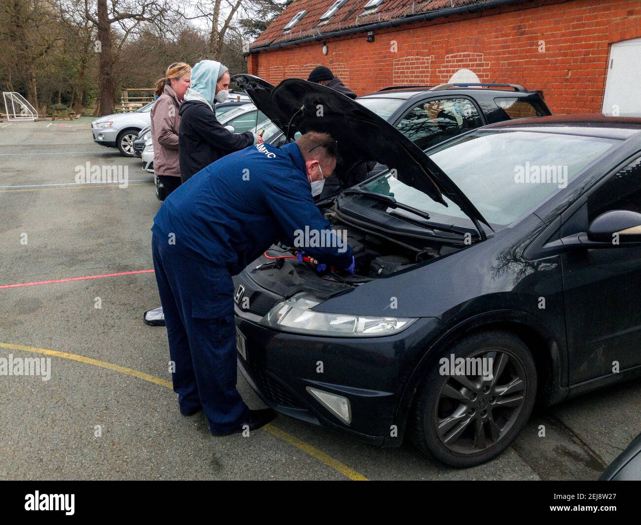 People attempting to jumpstart a broken down car in a carpark, London, UK Stock Photo Alamy
