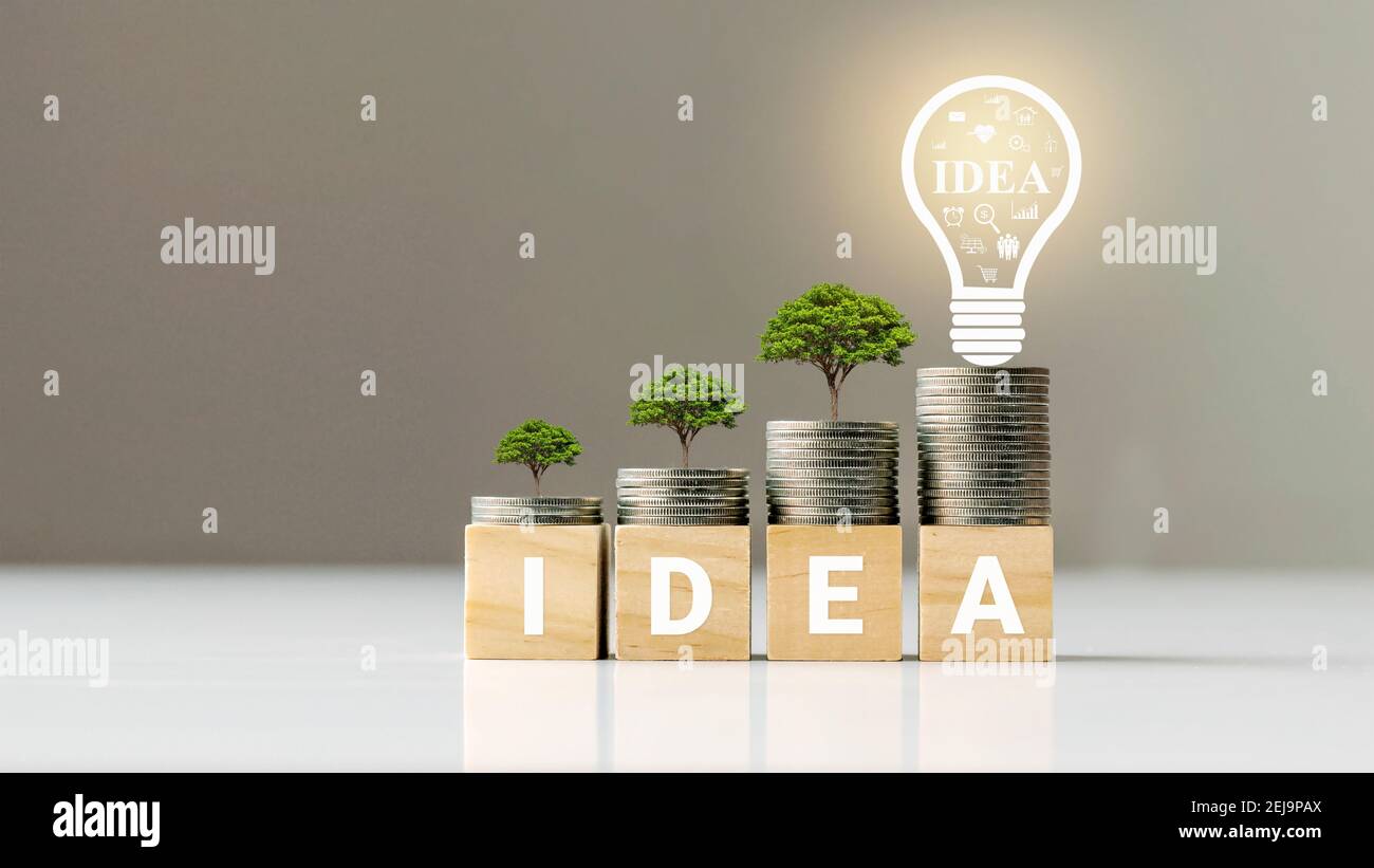 Growing tree on coin pile and wood block with text, financial management idea and business management intelligence. Stock Photo