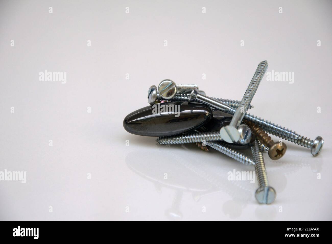 Magnet, with several screws in white steel, attracted by the magnetism of the magnet, white background, copy space, Brazil, South America Stock Photo
