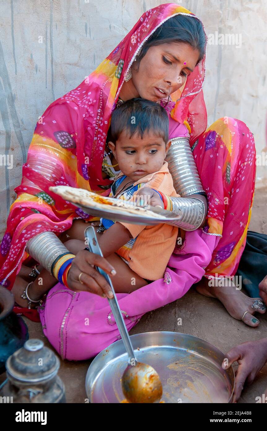 Rajasthan. India. 07-02-2018. Mother cooking for children in rural community. Women apart of taking care of children, they have an important role fina Stock Photo