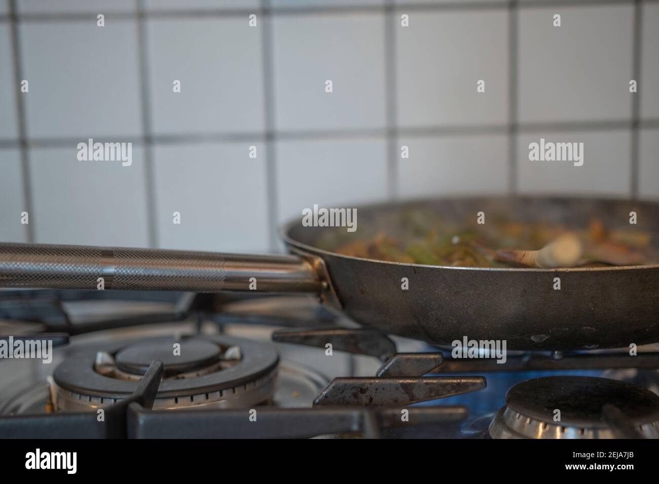 Frying bacon in stainless steel frying pan on stove top Stock Photo - Alamy