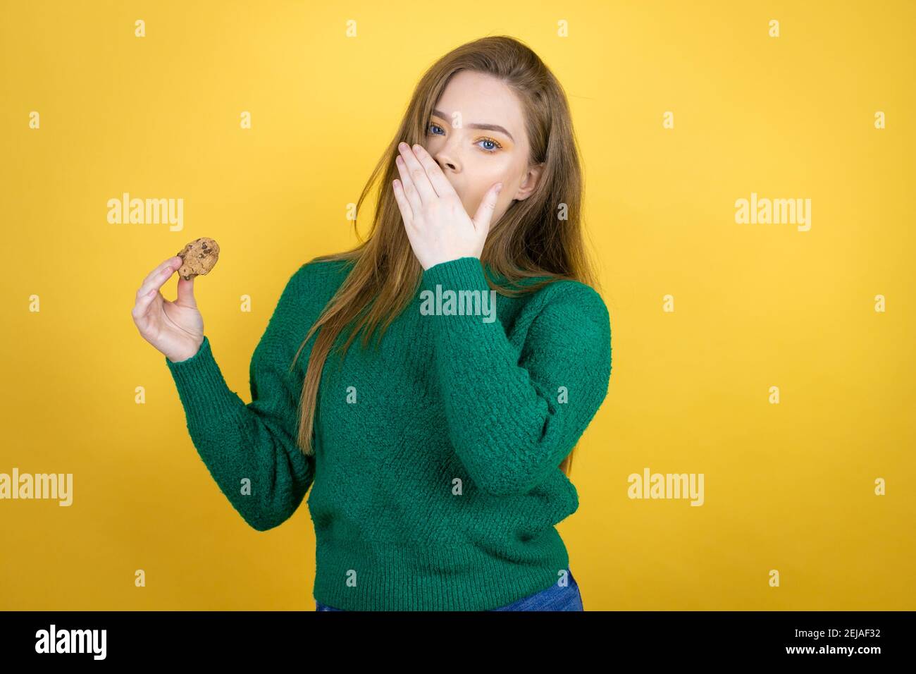 Young Beautiful Woman Eating Chocolate Cookie Over Yellow Background Bored Yawning Tired 9715