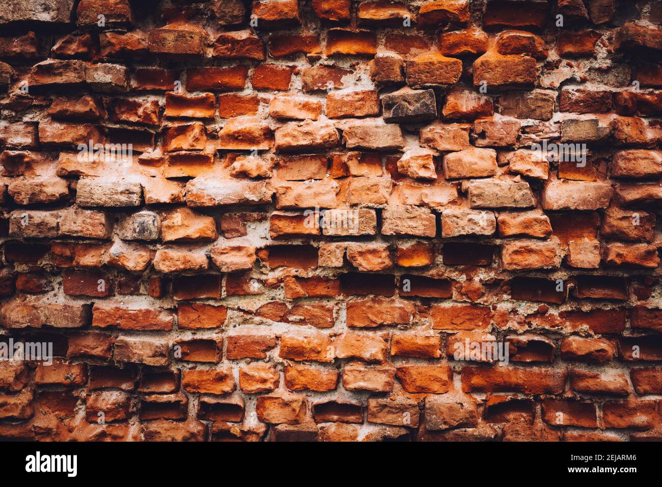 Old damaged wall made from red bricks. Background. Vintage architecture. Stock Photo