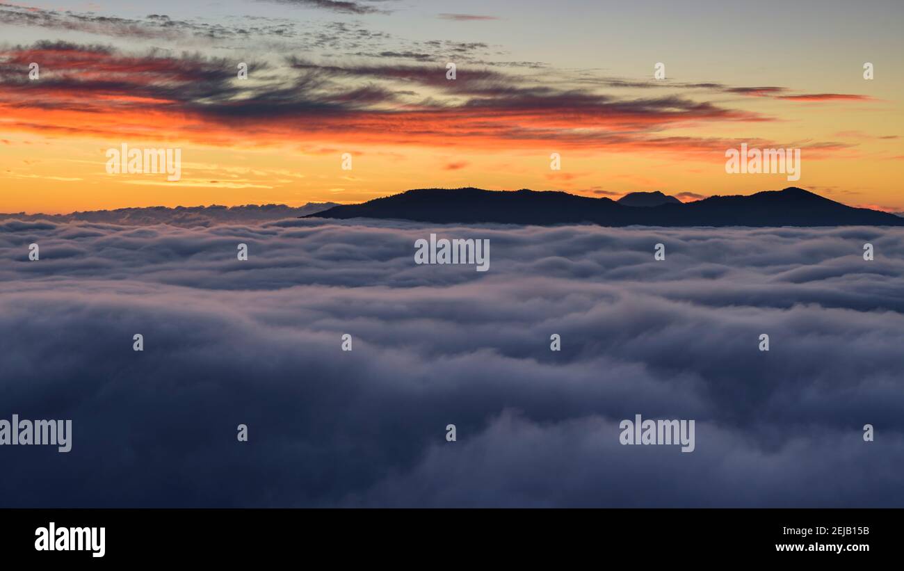 Sunrise over a sea of clouds seen from the Avenc de Tavertet Cliffs (Collsacabra, Catalonia, Spain) Stock Photo