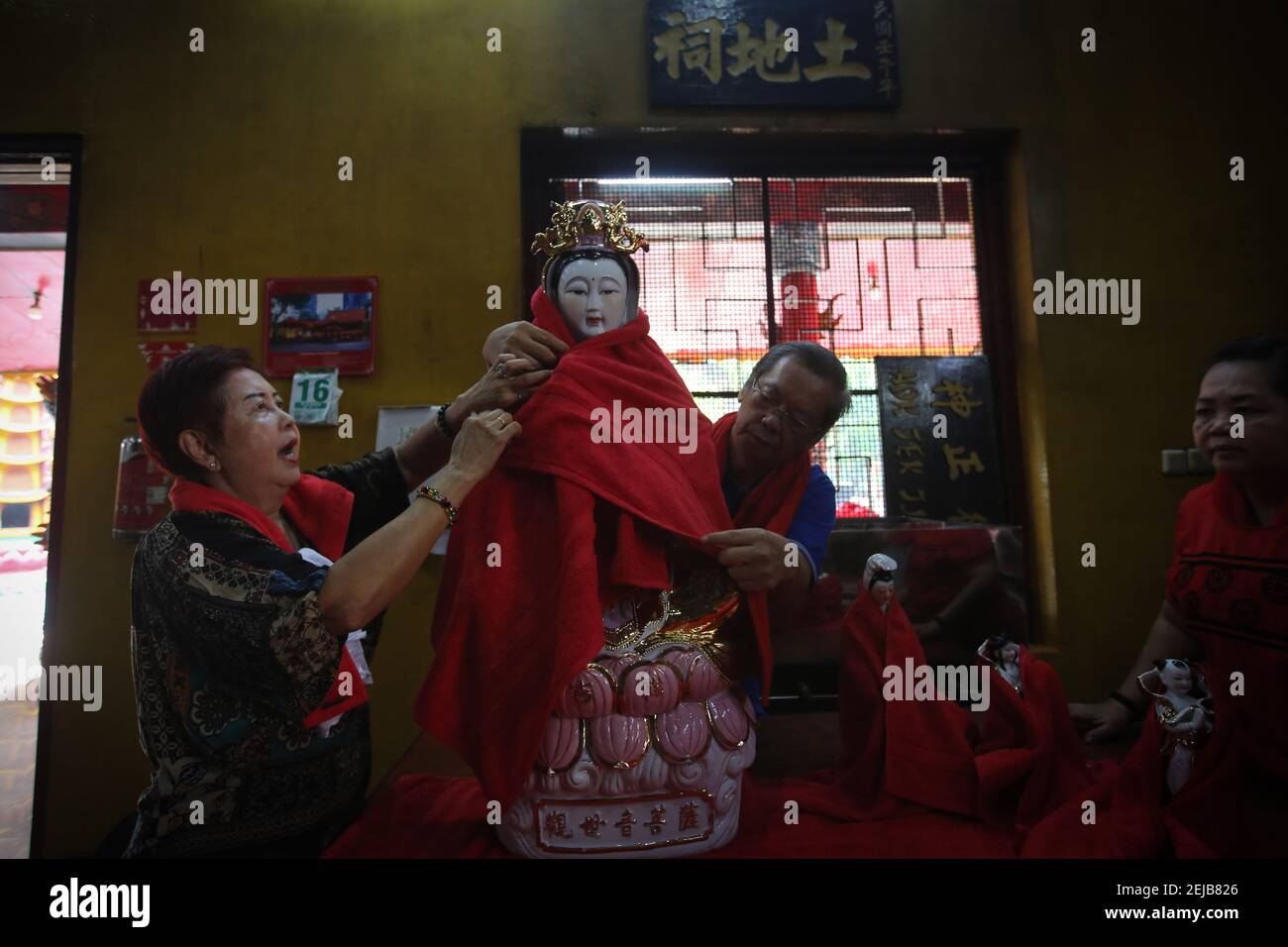 Chinese descendants cover a statue with a piece of cloth during the