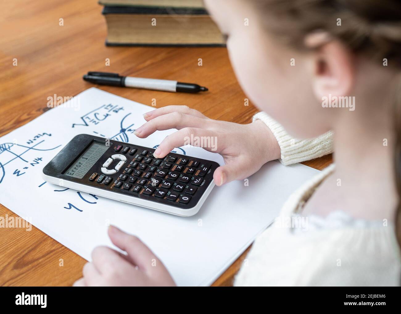 Calculation error young girl using calculator with error message on LCD screen unable to solve complicated maths problems Stock Photo