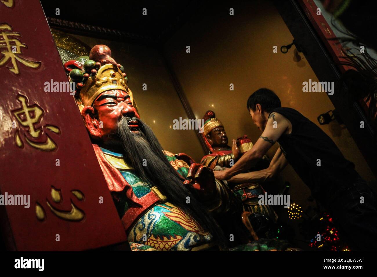A man cleans statues during the celebration at Dharma Ramsi temple in