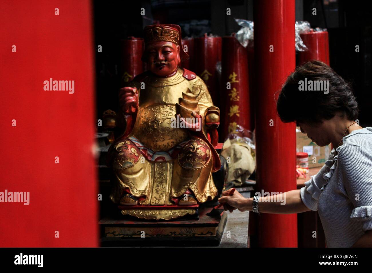 A woman brushes a statue during the celebration at Dharma Ramsi temple