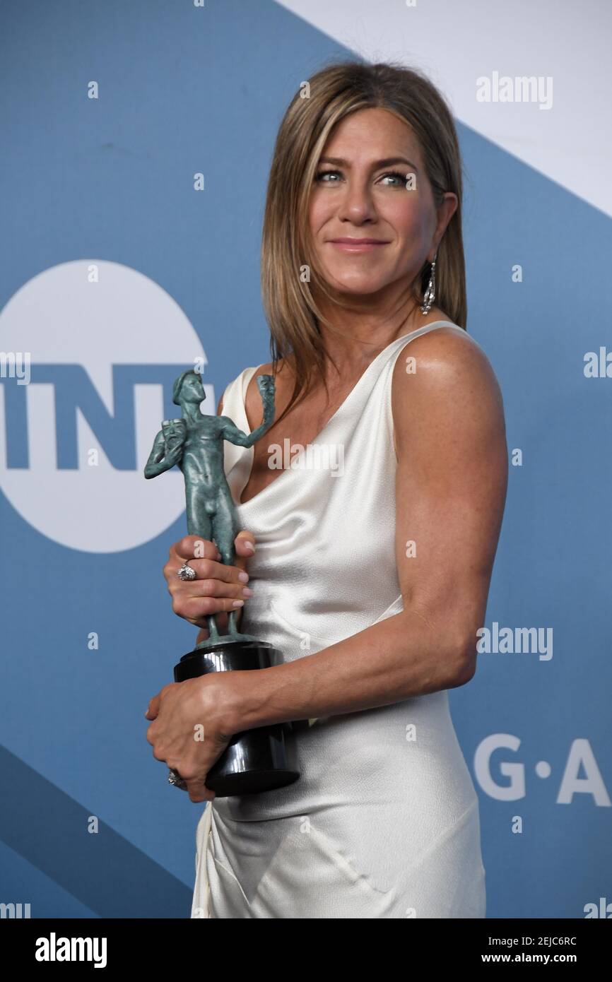 Jennifer Aniston poses in the press room after winning the award for