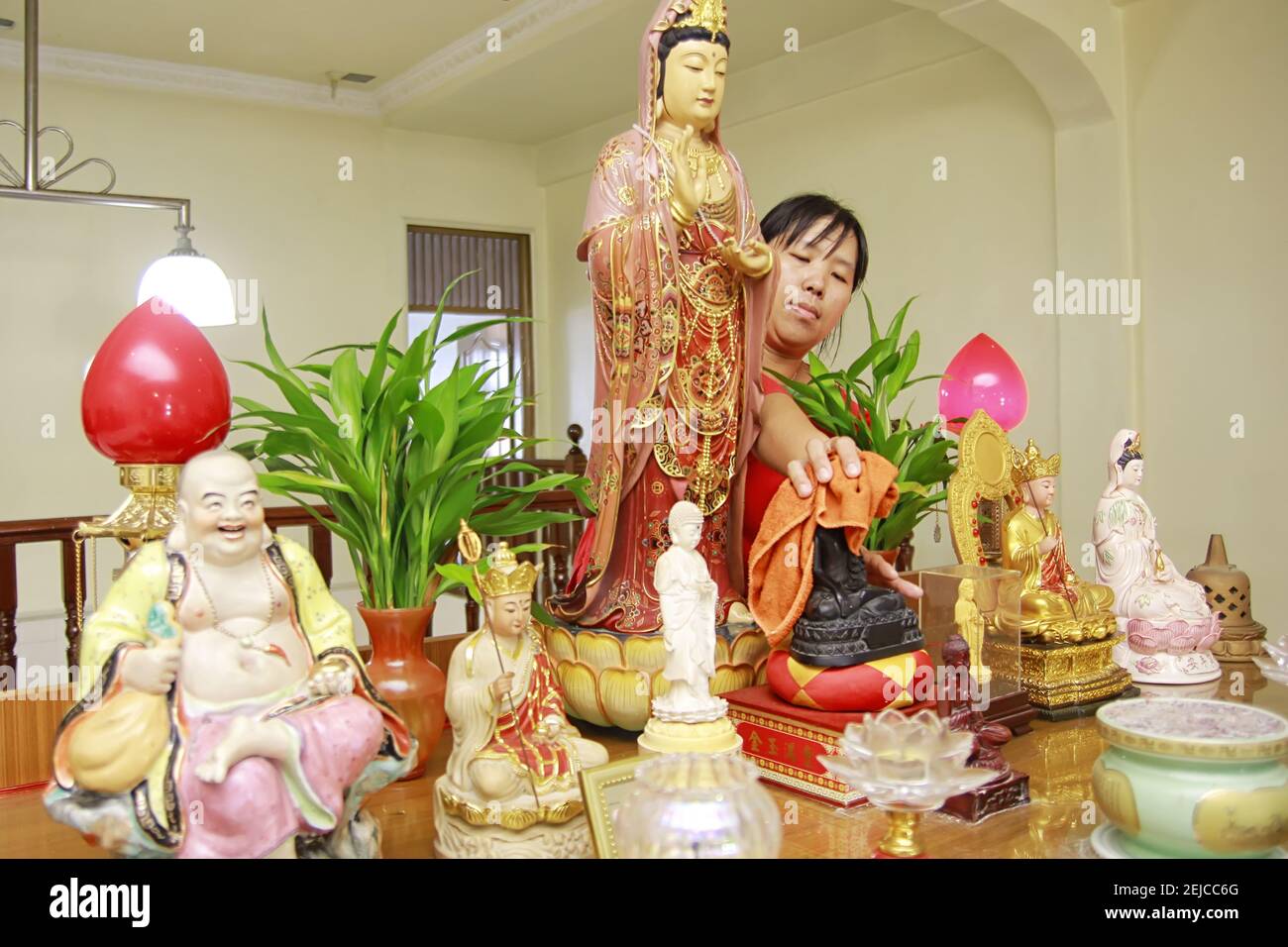 A woman cleans a buddhas statue during the celebration at Sakyamuni