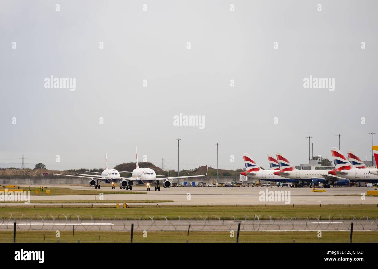 Two British Airways Airbus A320-232 taxi past others parked up. G-EUYY & G-EUYL. G-EUYY has Sharklet winglets fitted. London Heathrow Airport, London, Stock Photo