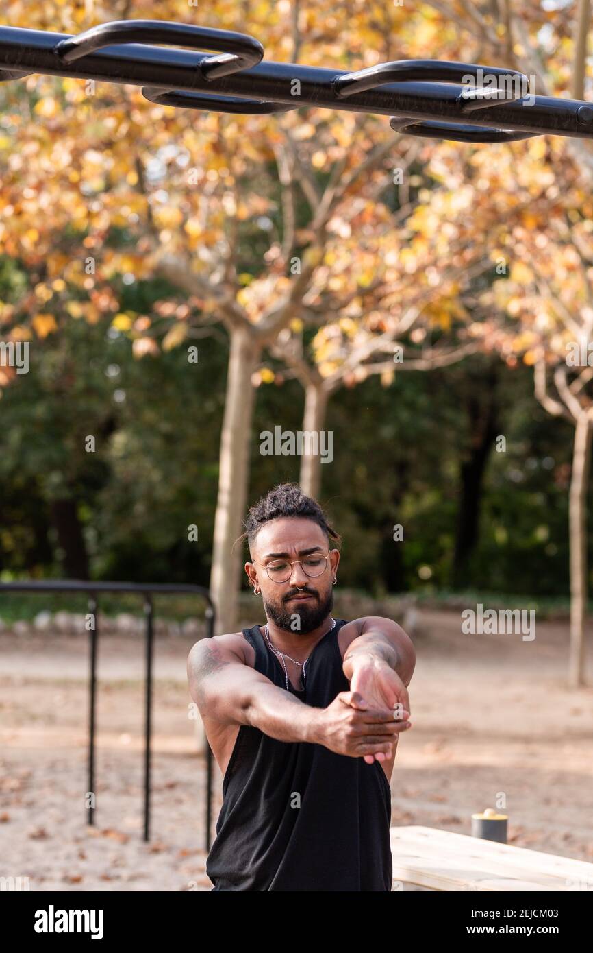 african american guy stretches after a fitness, calisthenics session in a park. Stock Photo