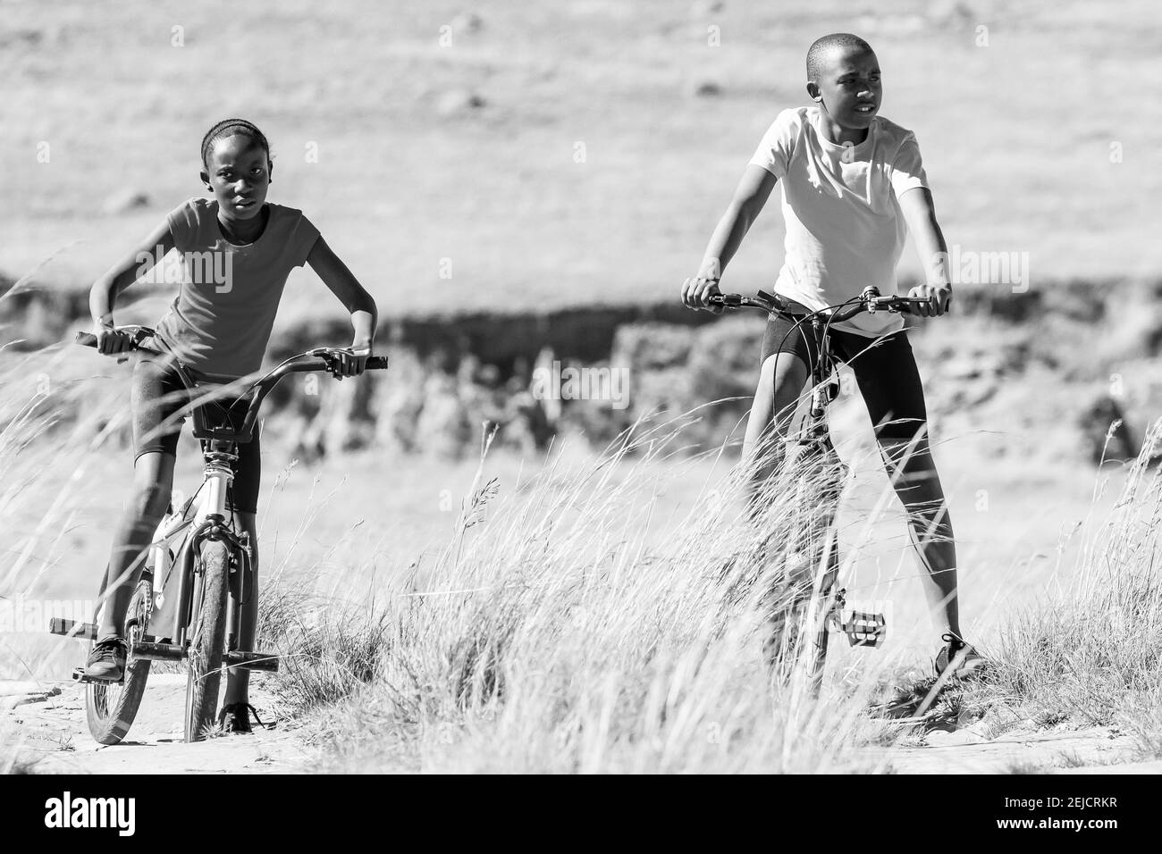 HARRISMITH, SOUTH AFRICA - Feb 20, 2021: Harrismith, South Africa - October 18 2012: African Children riding a bike in rural a village Stock Photo