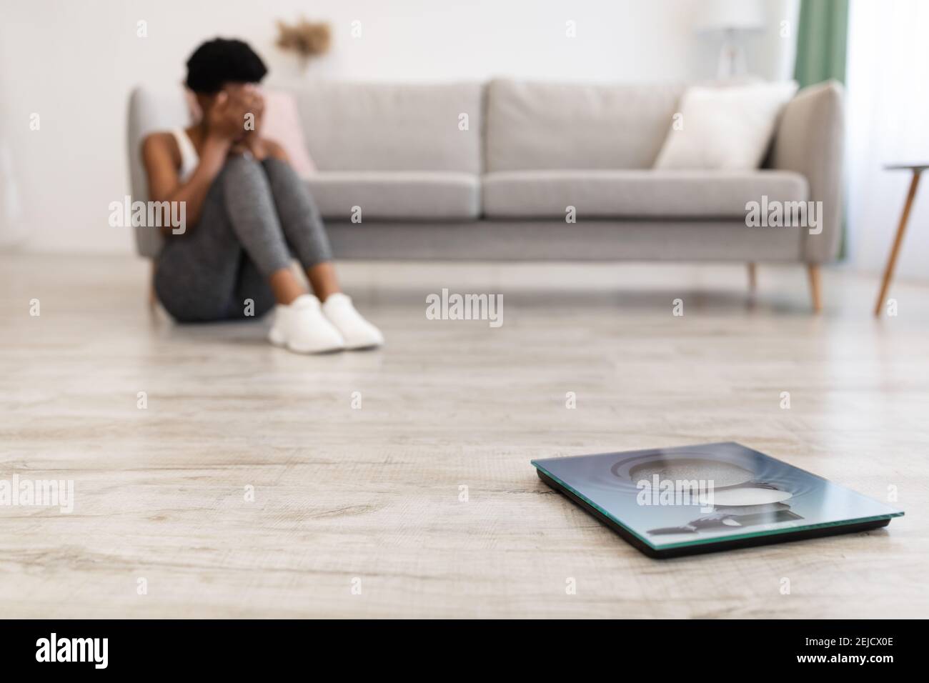 Woman Crying Sitting Near Scales After Slimming Failure At Home Stock Photo