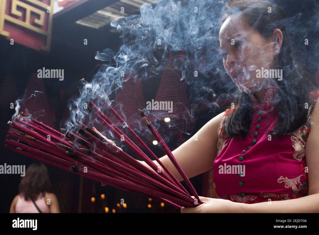 A woman burns incense while praying during the Chinese New Year