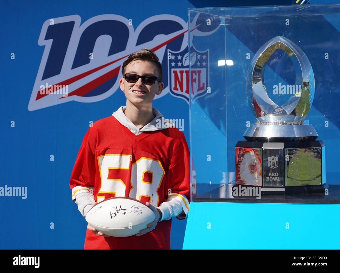 Jan 25, 2020; Kissimmee, Florida, USA; A fan wearing the Kansas City Chiefs  jersey of former linebacker Derrick Thomas (58) poses with the Pro Bowl  most valuable player trophy at the Pro