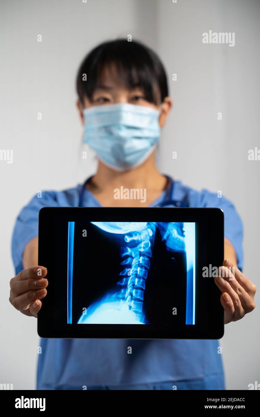 Female doctor holding a screen with x-ray of cervical vertebrae Stock Photo